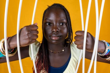 Güzel Afrikalı genç kız hapishane parmaklıklarını kırıyor. Dünyadaki özgürlük kavramı. 