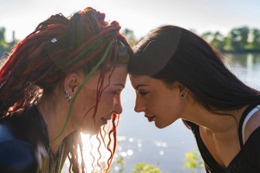 Alnı birbirine değen, samimiyeti yansıtan ve duygusal bağ kuran iki kadın.