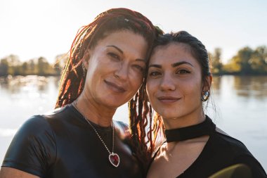 Rastalı iki kadın gölün kenarında bir anlık sevgi paylaşıyorlar.