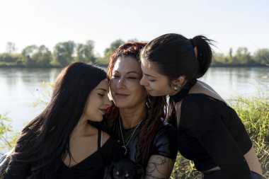 Nehir kıyısında sevgi ve şefkat gösteren aile güneşli bir günde