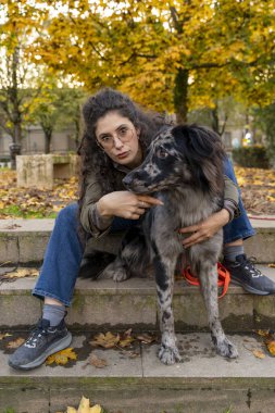 Kadın ve köpeğinin sonbahar parkında bir dakikalık dostluğu var.