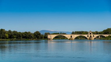 Açık mavi gökyüzünün altında tarihi pont d 'avignon ve mont ventoux