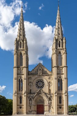 Saint baudile church featuring intricate gothic revival architecture under blue sky