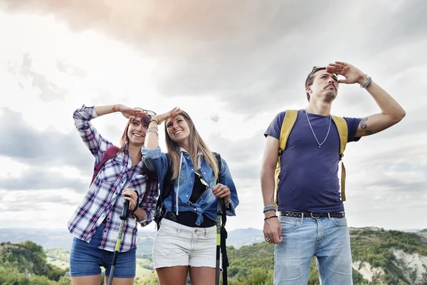 Grupo de jovens adultos olha para o horizonte durante a caminhada — Fotografia de Stock