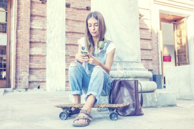 güzel kız onun smartphone cep telefonu ile müzik dinler