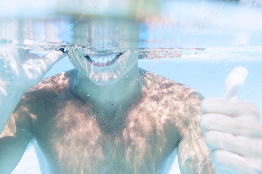 young man takes a call to smartphone underwater