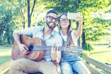 aşık genç çift selfie çalış gitar süre alır