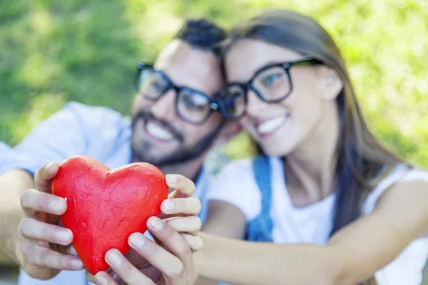 Joven pareja mostrando un corazón como símbolo de amor —  Fotos de Stock