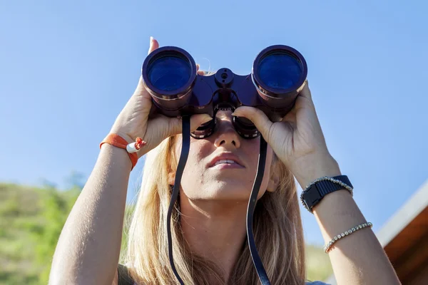 Bonita chica con prismáticos mirando al horizonte — Foto de Stock