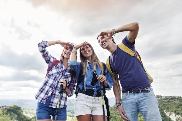 Skupina mladých dospělých vypadá na obzoru během turistiky — Stock fotografie