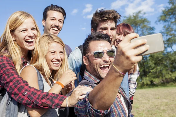 Grupa uśmiechniętych przyjaciół robi selfie — Zdjęcie stockowe