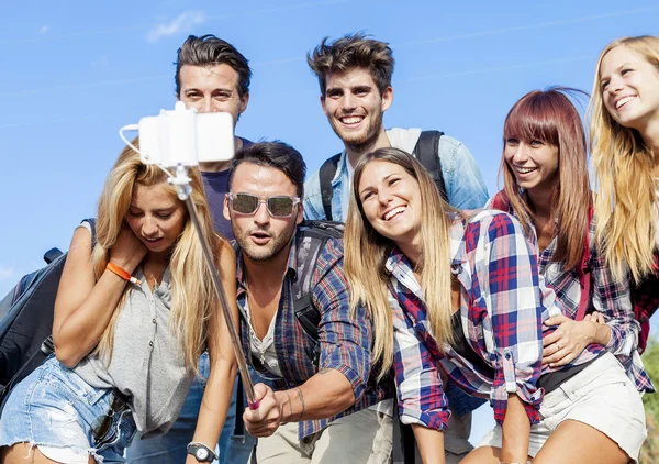 Grupo de amigos fazendo um auto-retrato com vara selfie — Fotografia de Stock