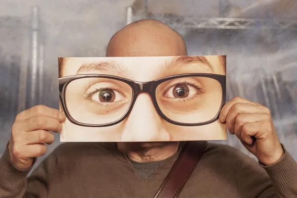 Kale man met een kaart met een grote glazen op het — Stockfoto