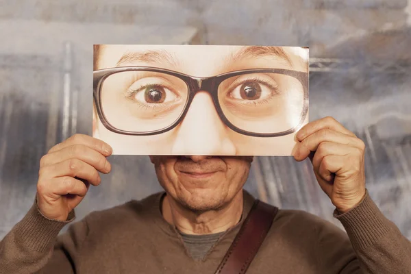 Calvo sosteniendo una tarjeta con unas gafas grandes — Foto de Stock