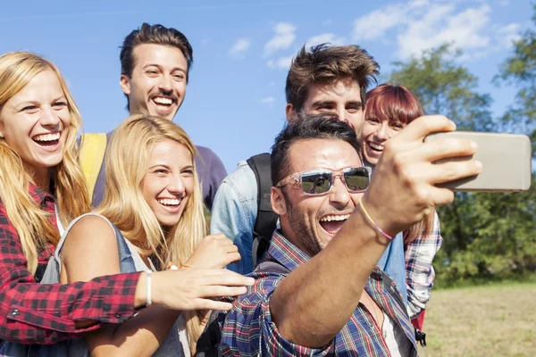 Grupo de amigos sorridentes tomando selfie com smartphone — Fotografia de Stock