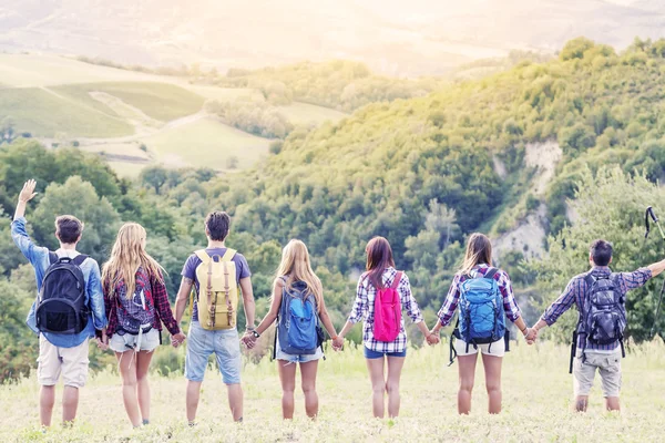 Group of hikers in the mountain in single file holding hands — Stock Photo, Image