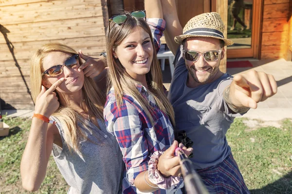Grupa przyjaciół uśmiechający się biorąc zabawny selfie z inteligentny telefon — Zdjęcie stockowe