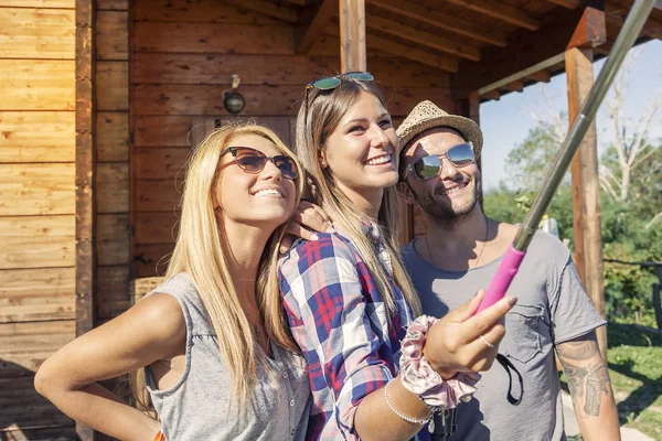 Skupina usmívající se přátel, přičemž legrační selfie s Kobaltová modř telefon — Stock fotografie