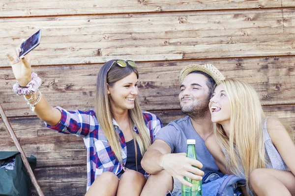 Gruppo di amici sorridenti prendere divertente selfie con smart phone — Foto Stock