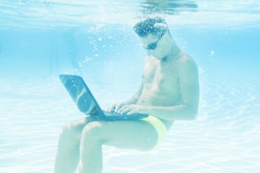 young man working with his laptop underwater
