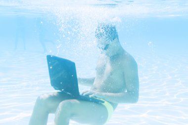 young man working with his laptop underwater