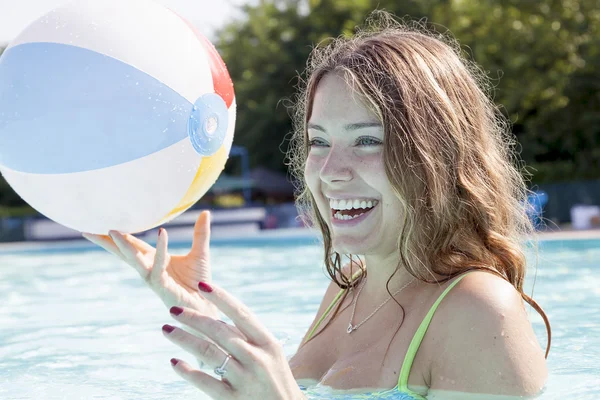 Retrato de hermosa chica jugando con la pelota en la piscina — Foto de Stock