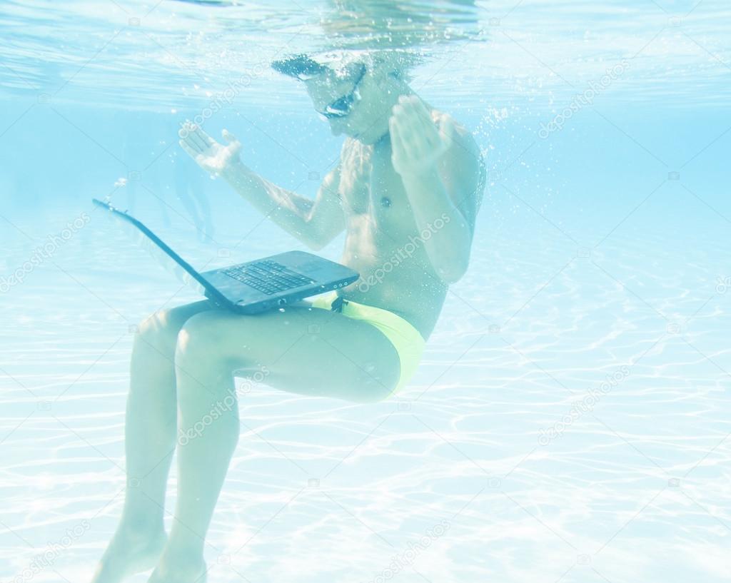 young man working with his laptop underwater