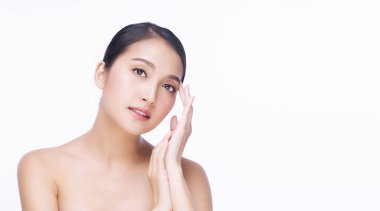 Güzellik kozmetiği ve sağlıklı konsept. Çekici genç bir kadın temiz teniyle yüzüne dokunuyor izole beyaz arka plan üzerinde. 