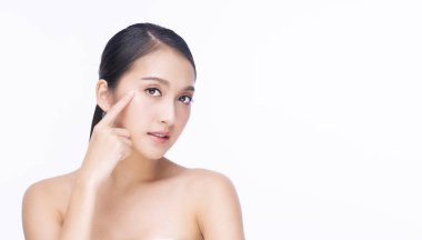 Güzellik kozmetiği ve sağlıklı konsept. Çekici genç bir kadın temiz teniyle yüzüne dokunuyor izole beyaz arka plan üzerinde. 