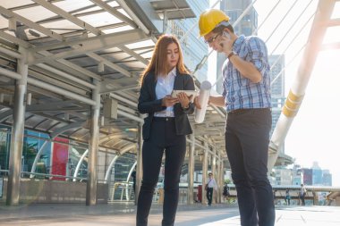 Genç mühendisler genç bir sekreterin ellerinde tablet arıyorlar..