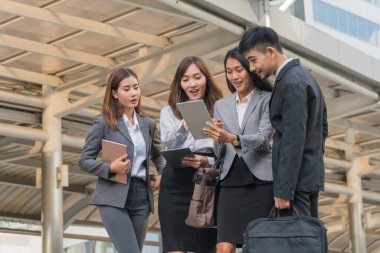 İş ekibi tablete birlikte bakıyor, başarılarından memnunlar..