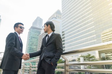 Modern bir şehirde yakışıklı bir iş adamı tokalaşması.