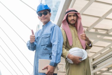 Arap işadamları ve akıllı ustabaşı modern şehirde başparmağını kaldırdı