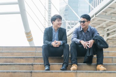 Yakışıklı genç işadamı merdivenlerde oturmuş proje hakkında konuşuyor..