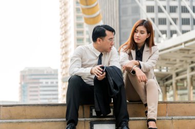 İki Asyalı iş adamı merdivenlerde modern şehirde iş planı hakkında konuşuyorlar. Boşluğu kopyalayın.