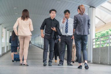 Bir grup meşgul iş adamı üstgeçit köprüsünde hareket halinde. Aceleyle yürüyen genç işadamlarına odaklan..