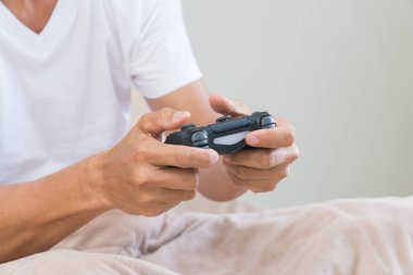 El genç adam bir joystick oyunu basıyor.