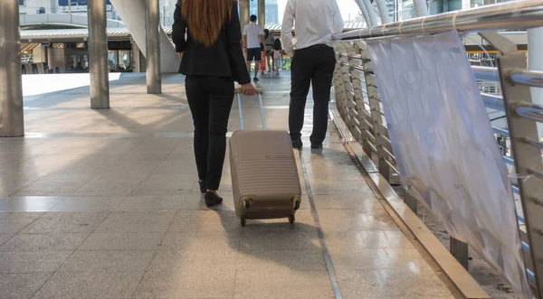 スーツケース袋を引っ張って街を歩くビジネス女性を — ストック写真