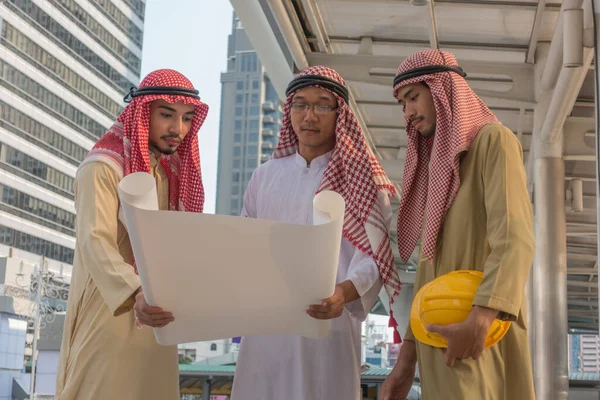 三位阿拉伯商人正在俯瞰蓝图 进行咨询 — 图库照片