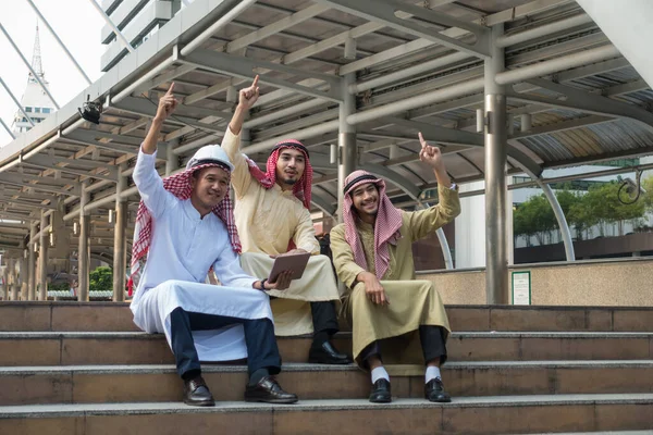 Три Арабских Бизнесмена Сидят Лестнице Поднимают Руки Современном Городе Концепция — стоковое фото