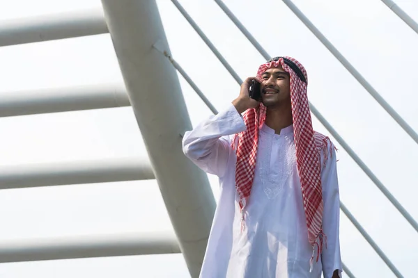 阿拉伯商人站在现代城市的智能手机上聊天 — 图库照片