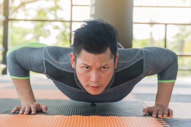 Yakışıklı adam şınav pozisyonunda egzersiz yapıyor..