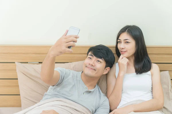 Jovem Feliz Casal Asiático Tomando Selfie Com Telefone Inteligente Cama — Fotografia de Stock