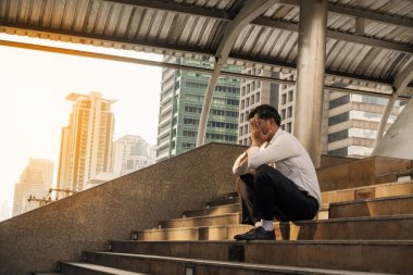 İş başarısızlığı ve işsizlik sorunu kavramı. Merdivenlerde elleri yüzü kapalı oturan yorgun, orta yaşlı bir adam. İşsiz İşadamı hayal kırıklığına uğramış ve çaresizce iş arıyor..