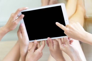 Odaklan. Üç genç kadın, yatakta yatarken kafalarında tablet tutuyorlar..