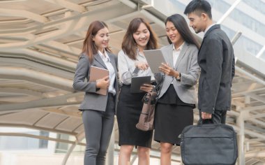 İş ekibi tablete birlikte bakıyor, başarılarından memnunlar. Grup ofisindekiler yeni projelerini dışarıda konuşuyorlar. Takım çalışması konsepti.