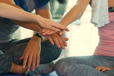 Spor salonunda el ele tutuşan sporcuların elleri. Spor salonunda bir sürü eli olan bir grup arkadaş. Takım çalışması ve liderlik kavramı.