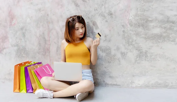 매력적 여성들이 카드로 온라인 상거래를 패션을 카드를 여자가 쇼핑백과 노트북을 — 스톡 사진