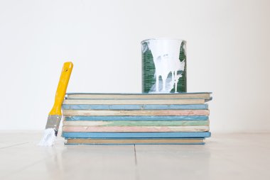 Kitaplar vintage yığını üzerinde beyaz boya ile sarı boya fırçası