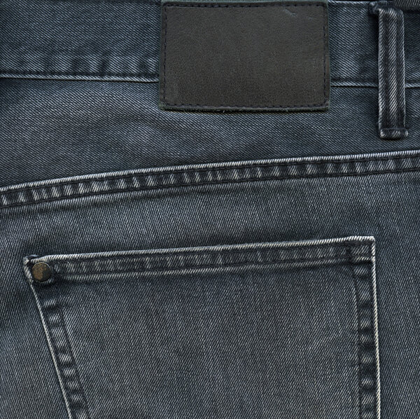 Фон из черных джинсов с карманной и черной этикеткой
